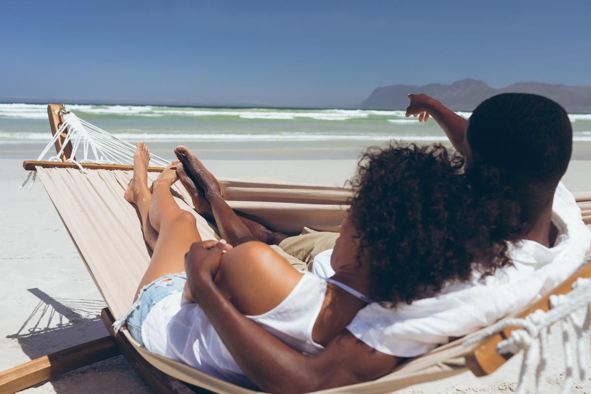 A photo of a man and woman sitting on the beach